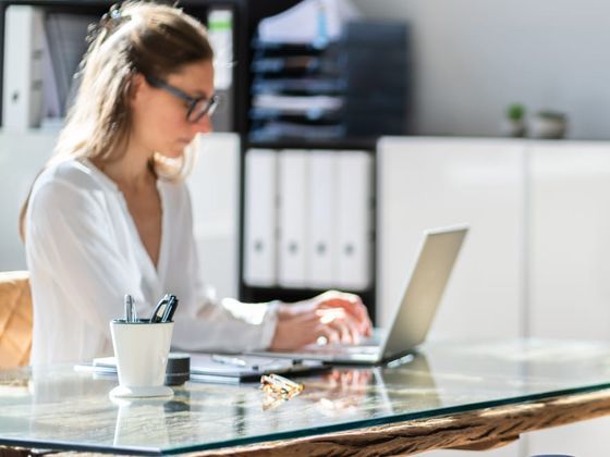 A benefits advocate working at a laptop in a bright office